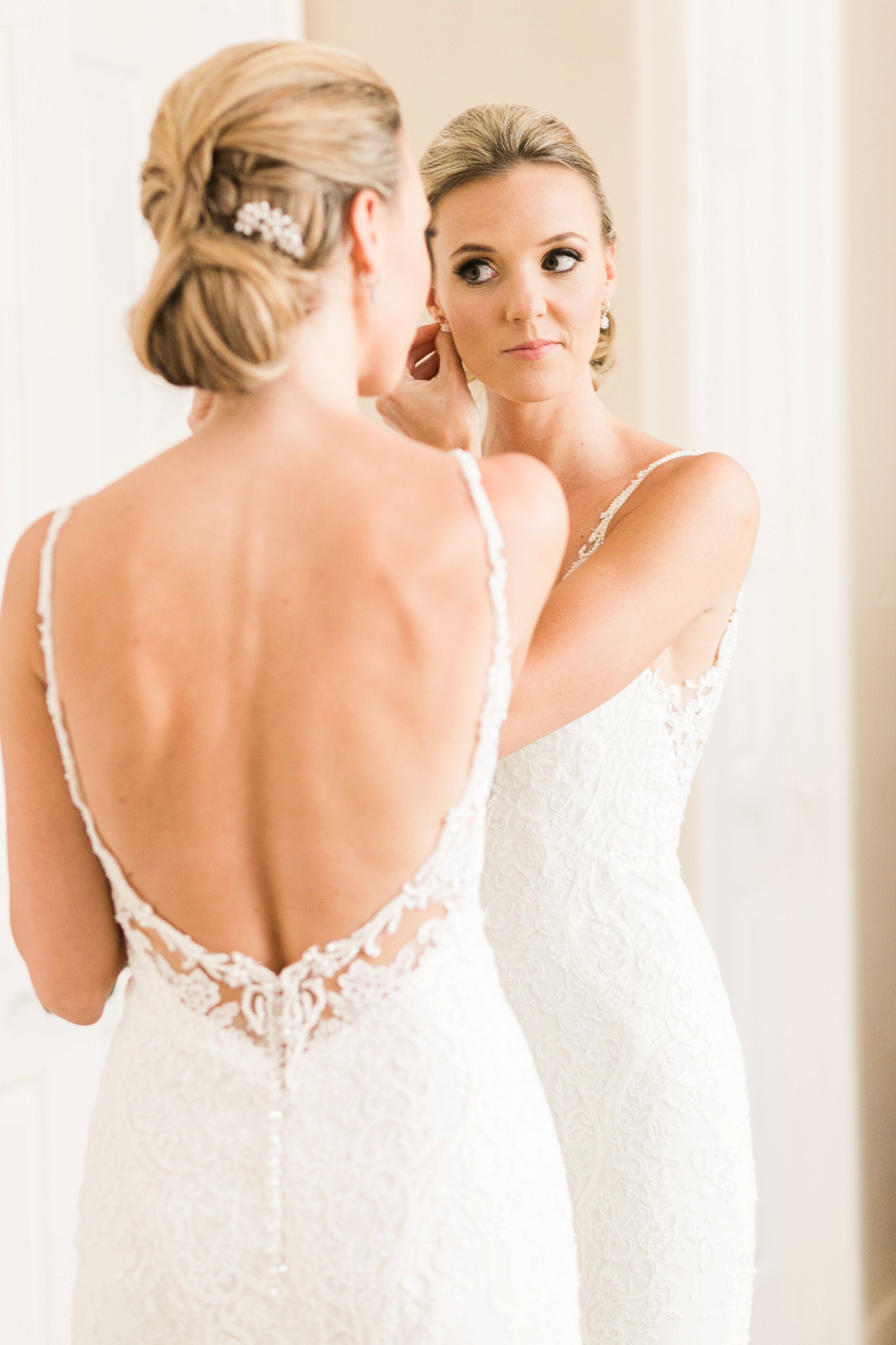 Bride putting on earrings