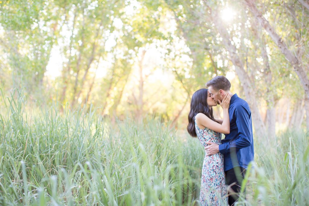 Couple kissing in grass field